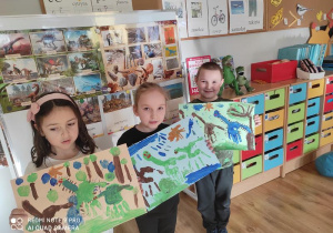 Dzieci prezentują namalowany park jurajski.